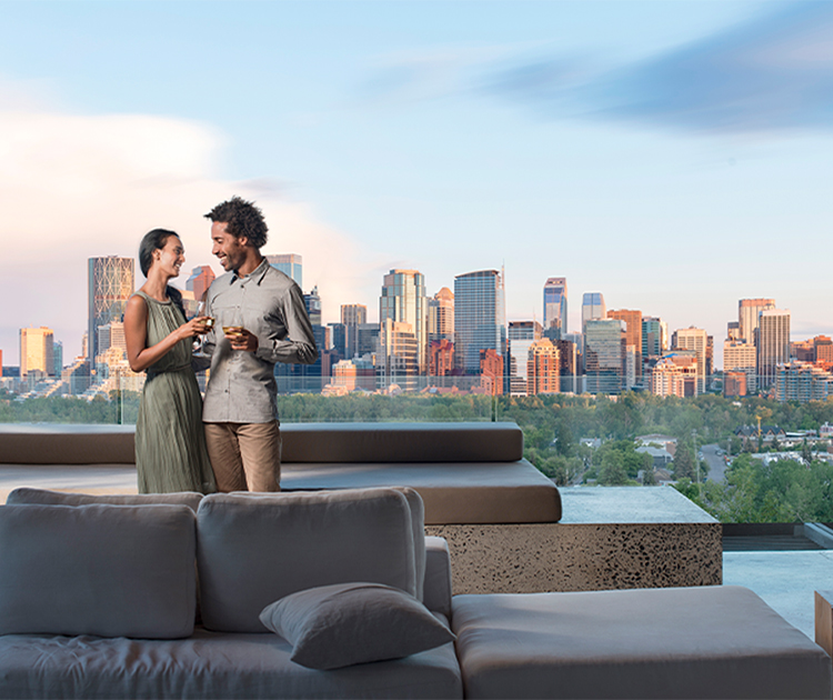 Couple having a glass of wine together with a skyline view of Calgary in the background